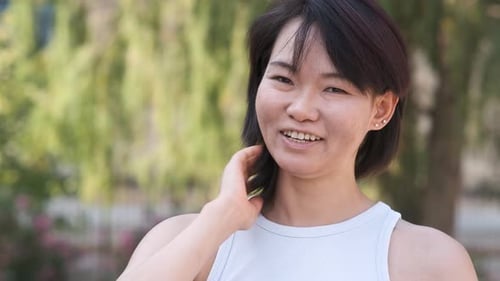 Happy Woman with Black Hair in City Park During Daytime