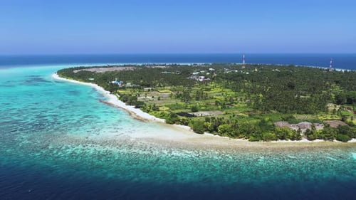 Aerial view of island with turquoise ocean and coral reef, Maldives.