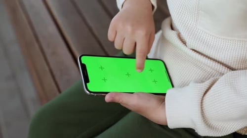 Child Using Smartphone With Green Screen Display