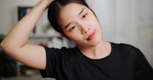Young Woman Stretches Neck Muscles Indoors