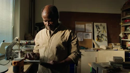 Senior Carpenter Using Digital Tablet in Woodworking Workshop