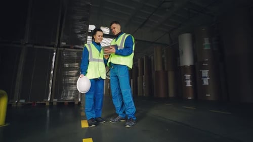 Engineers are Talking in the Warehouse of a Cardboard Factory