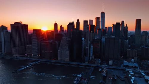 Sun setting behind the skyline of New York, United States. Aerial scenery of the city skyscrapers