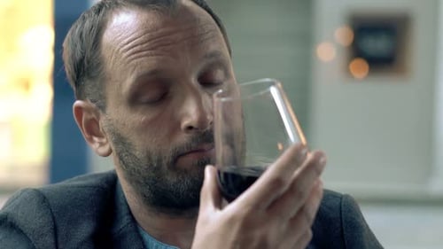 Sad, Drunk Man Drinking Red Wine Sitting in Cafe 30s