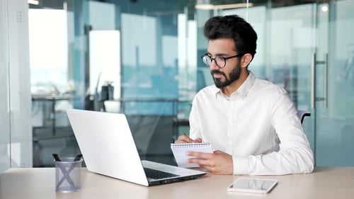 Young Adult Working at Laptop in Modern Office