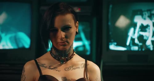 Woman with Tattoos and Piercings Poses in Dark Room