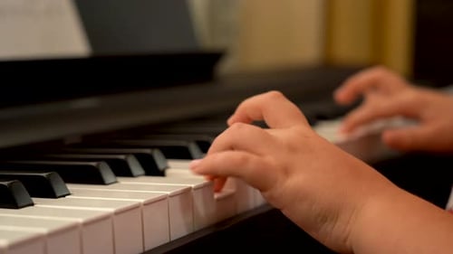 Child Plays Piano Keyboard in Home