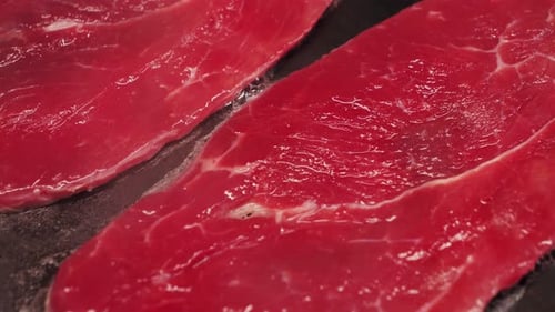 Two Juicy Beef Steaks Frying in a Pan