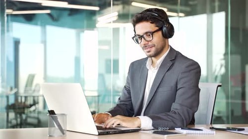 Young Professional Working on Laptop Wearing Headphones
