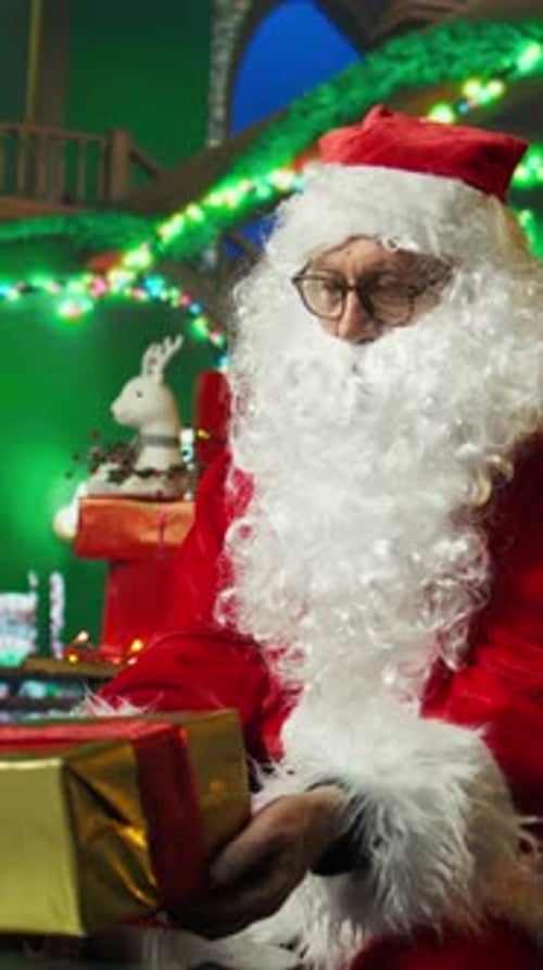 Santa Claus Examining a Christmas Present Indoors