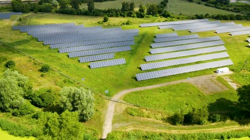 Aerial view of solar panel field on green grass