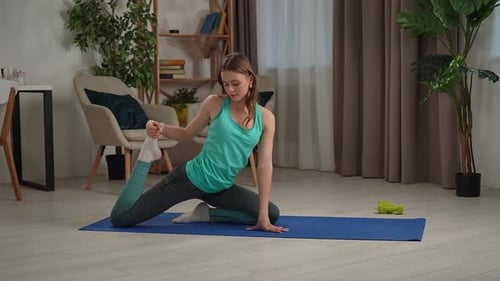 Young Woman Stretching on Yoga Mat at Home