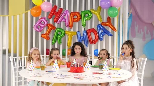 Girls Celebrate Birthday at Party with Cake and Balloons