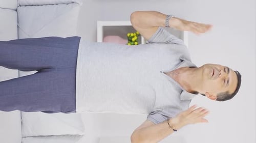 Vidéo verticale de Le vieil homme suffoque à cause de la chaleur à la maison