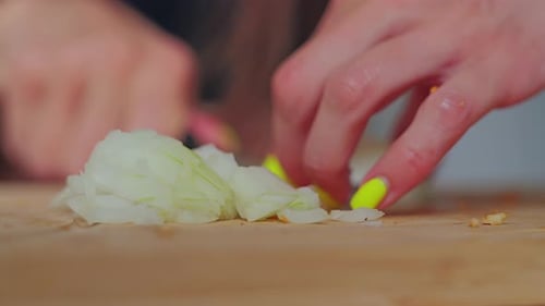 Close Up Chopped Onion Layers with Female Hands Cutting Vegetables in Soft Focus
