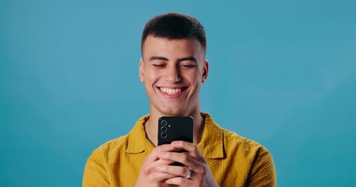 Happy man, phone and laughing for funny joke, social media or meme on blue studio background