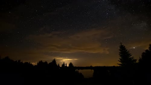Night Sky Time Lapse. Night sky over lake and trees.