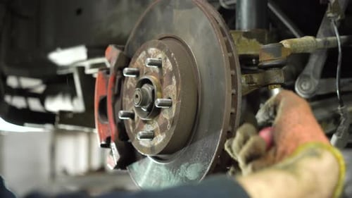 Mechanic Works on Auto Repair in Garage