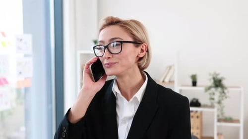 Businesswoman Discussing on Mobile Phone in Office Setting