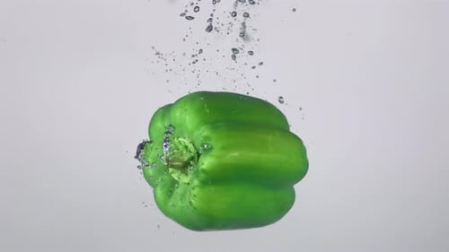 Grüner Pfeffer fällt ins Wasser