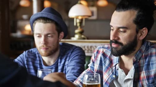Friends Having Beer and Snacks Inside Bar