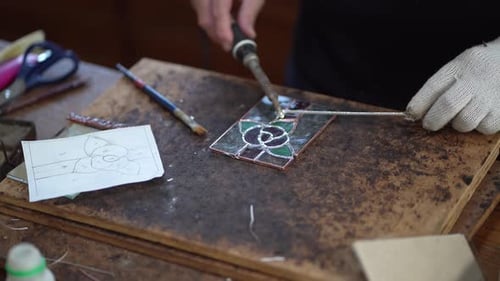 A woman making a stained glass work