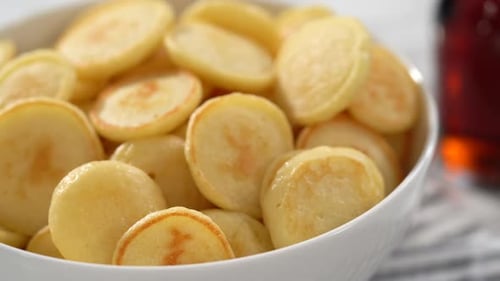 Step By Step Freshly Made Mini Pancake Cereal with Fresh Blueberries in a White Bowl