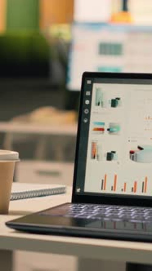 Vertical Video Forecasting Reports Running on Laptop Screen in Empty Business Office