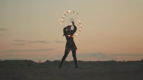Female Circus Performer Making Fire Show at Sunset