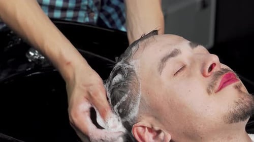 Man Enjoying a Relaxing Hair Wash By a Skilled Hairstylist