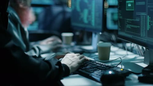 Coders Typing at Computers at Night in Office