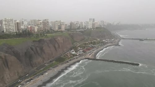 Vista aérea de hiperlapso brumoso sobre los acantilados costeros de la ciudad de Miraflores, Lima, Perú