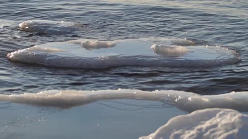 In the winter, stones are icy on the sea shore. Icicles hung from large pieces of ice