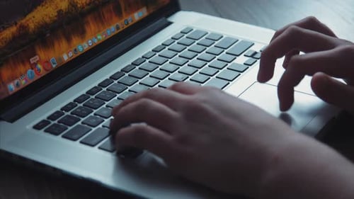 Hands Typing on Laptop Keypad