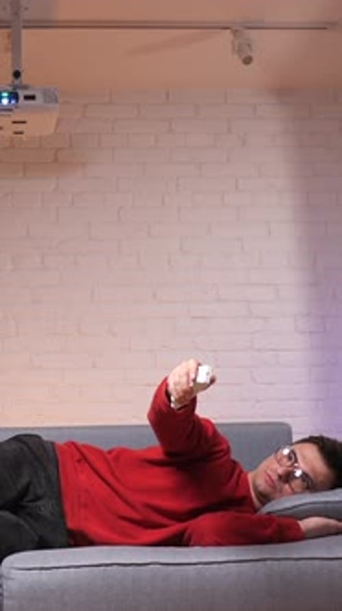 Young Adult Uses Projector From Couch