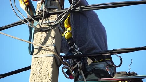 Lineman Working on Electrical Pole High Above City
