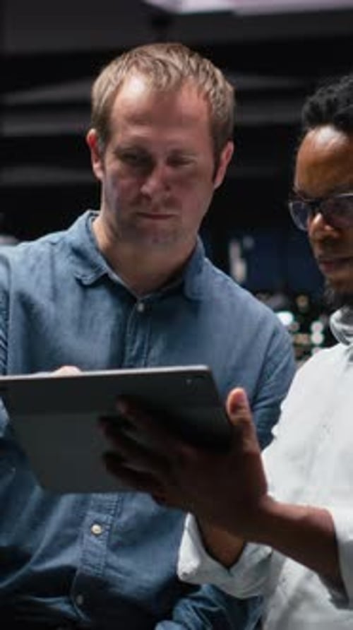 Vertical Video Engineering Team Using Tablet in Office Working with AI