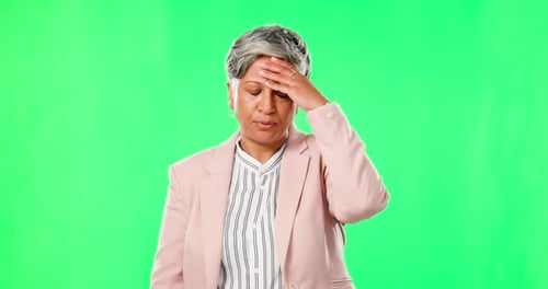 Anxiety, headache or mature businesswoman on green screen with burnout from mistakes