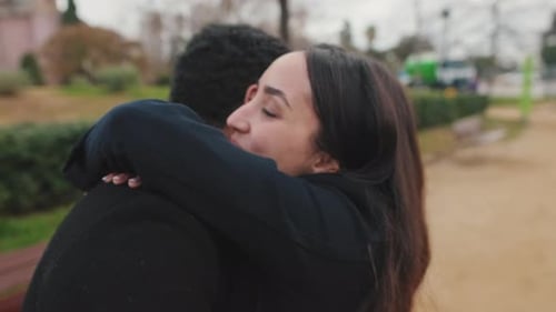 Young couple embracing in park.