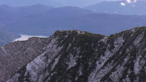 People enjoying the view, summit cross of Herzogstand mountain. Aerial