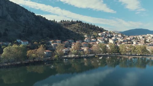 Drone orbit FLIGHT aside to a village on a hill in Europe, red roof tops, sunny weather, blue water