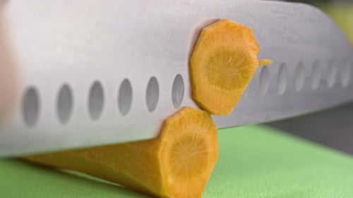 Slow Motion Closeup Video of Slicing Fresh Carrots for Soup