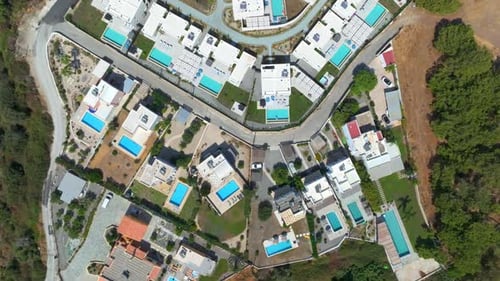Top down drone shot over vacation homes with pools at a holiday resort in Greece