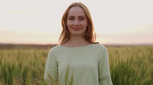 Portrait of a Young and Beautiful Farmer Woman Standing in the Middle of a Wheat Field