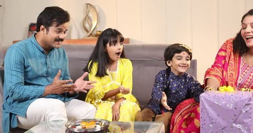 Family Joyfully Celebrates a Holiday with Gifts Indoors