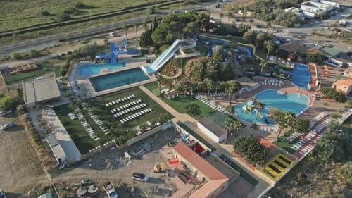 Aerial view revealing a large water park with swimming pools and slides
