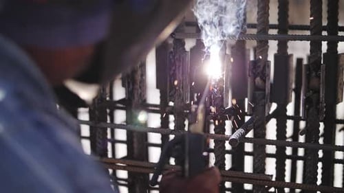 Construction Worker Welding Rebar in Urban Setting