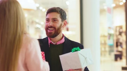 Smiling Father and His Daughter Exchanging Christmas Present Boxes Gifts on Shopping Center Talk Dad