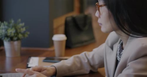 Young Asian Lady Freelancer Using Laptop Focused on Ecommerce Typing Working Indoors in Cafe