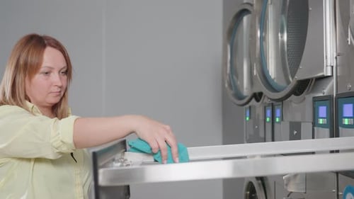 Laveuse et tiroir filtrant pour femme d'affaires avec serviette dans la laverie automatique